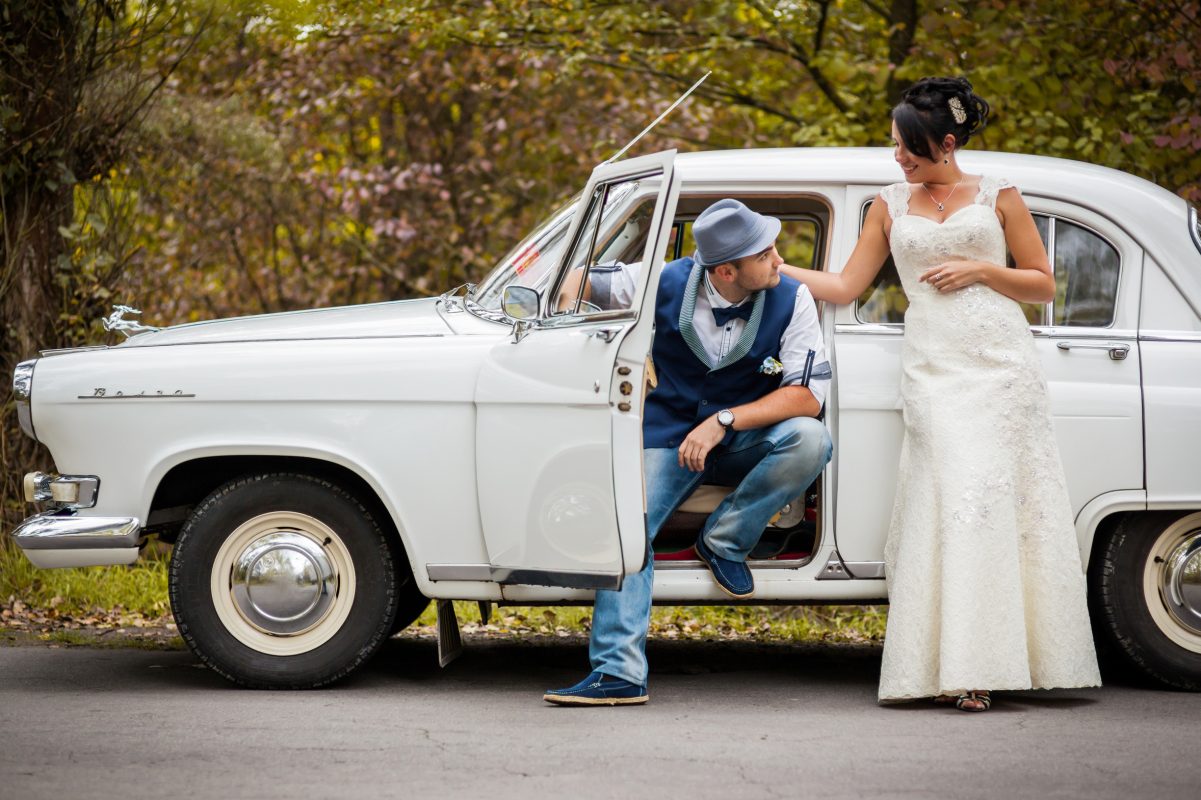 Bride and groom with vintage wedding car.