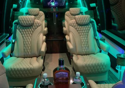 Luxurious limousine interior with leather seats and ambient lighting.